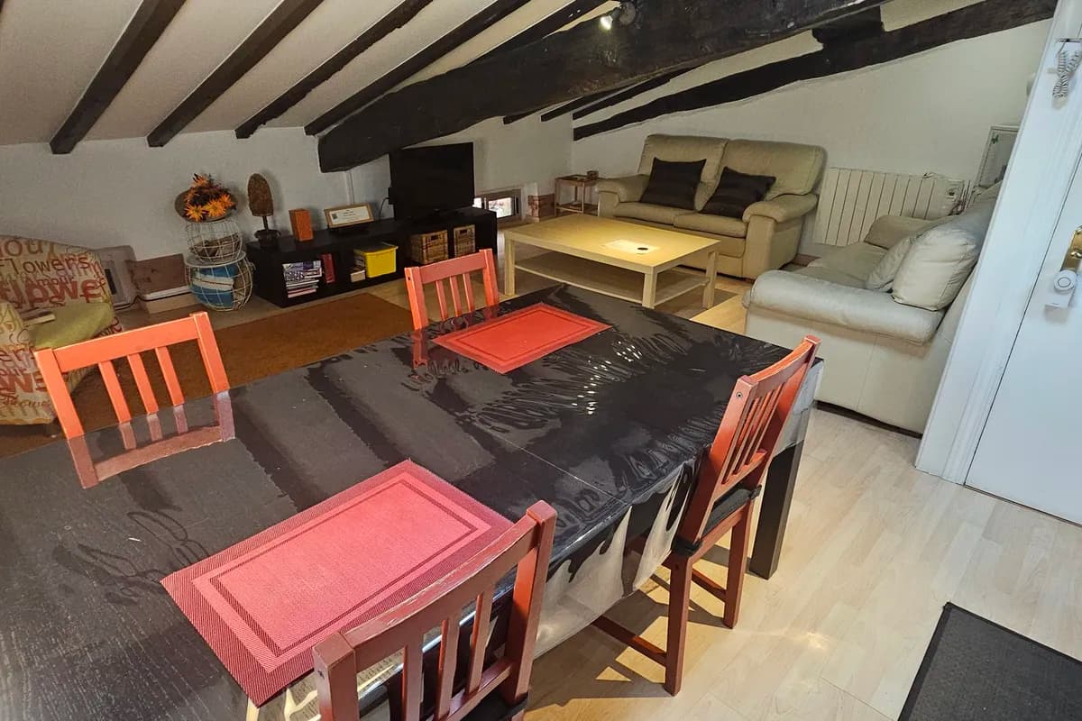 Salón comedor con mesa y vigas de madera